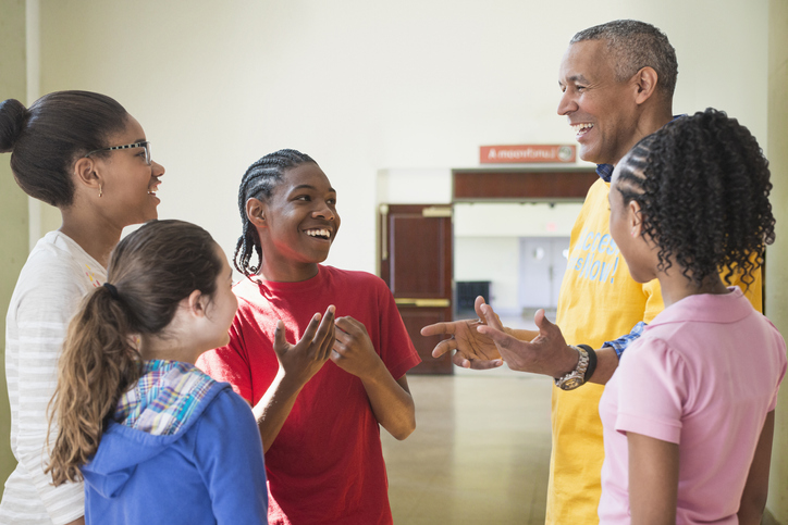 A group of two adults and three children talking